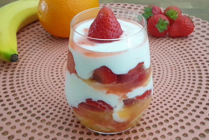 Griekse yoghurt met aardbeien, banaan en sinaasappel